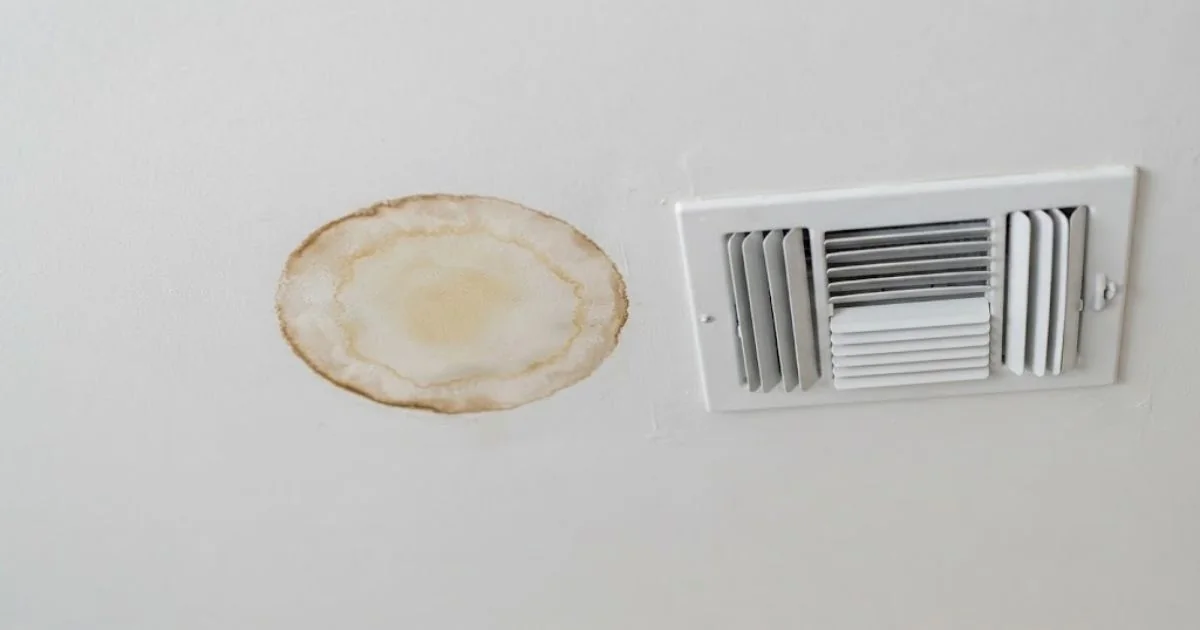 Water stain on a ceiling beside an AC vent