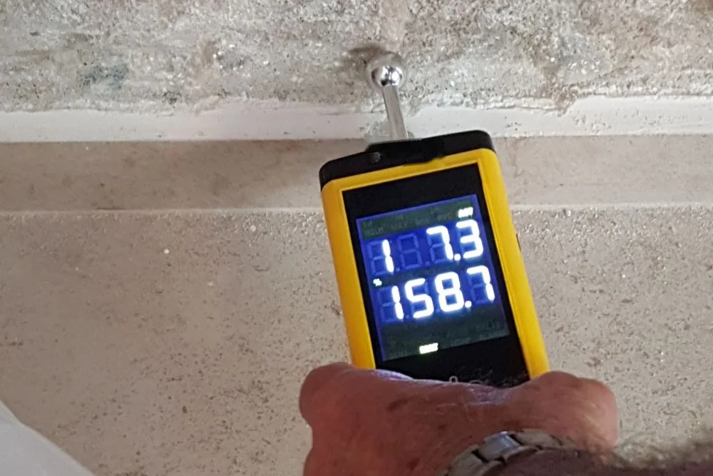 Moisture meter checking drywall after water damage